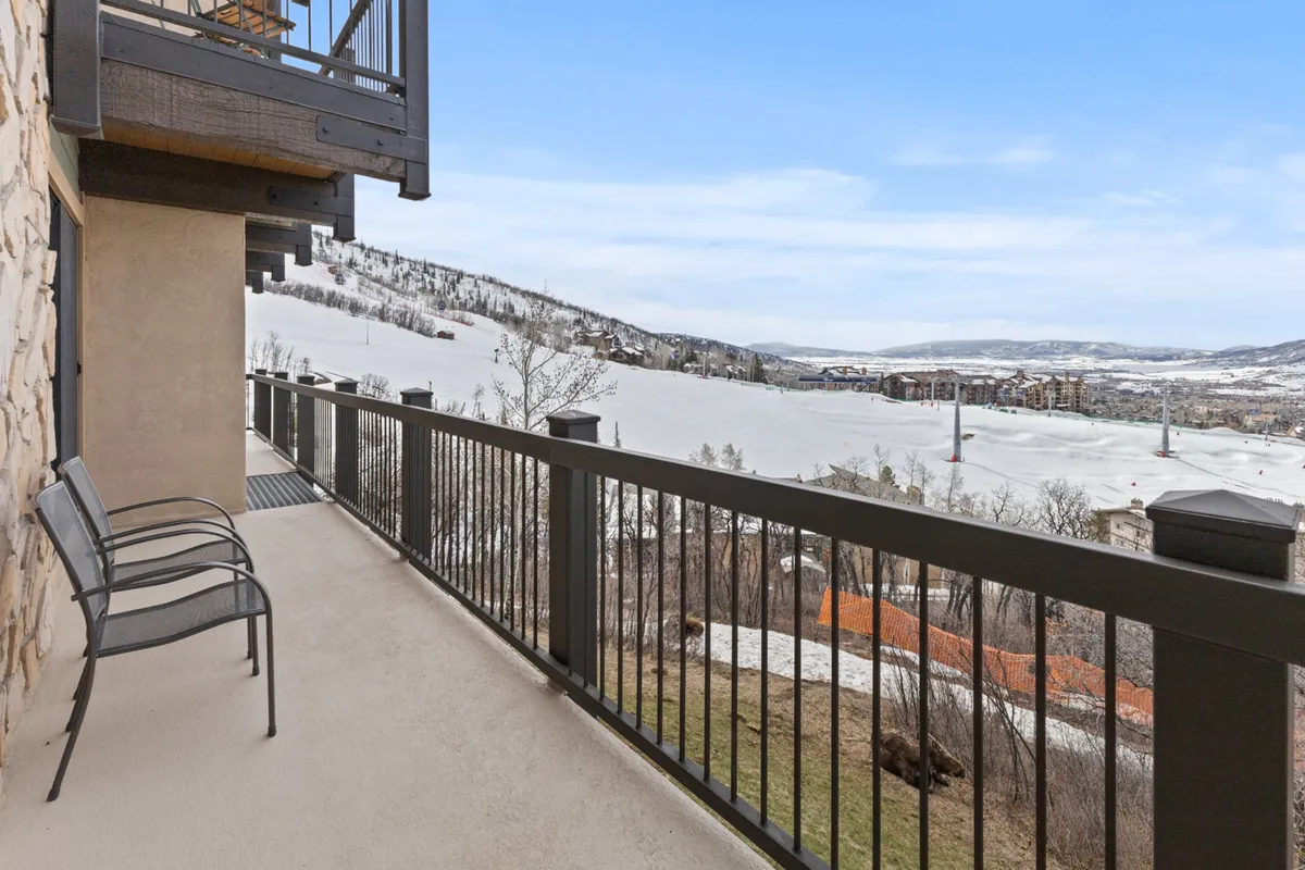 This image captures a serene balcony setting with comfortable seating overlooking a snow-covered landscape and expansive mountain views. The tranquil atmosphere is perfect for enjoying morning coffee or evening sunsets, with the snowy scenery providing a sense of escape and connection to Steamboat's natural beauty.